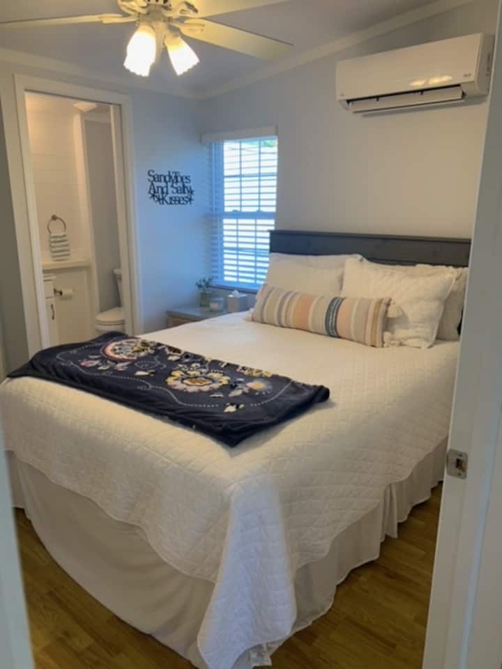 Master Bedroom (Bedroom three) - Queen bed, ceiling fan, small half bath, bedside table with two drawers, and closet.