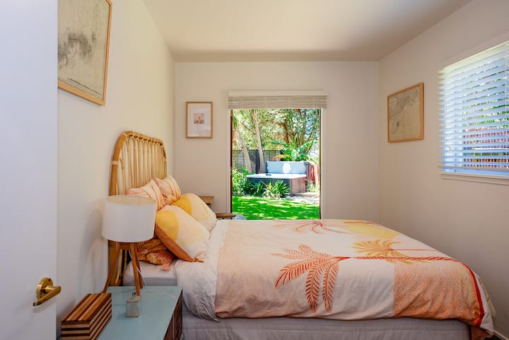 Dormitorio queen en la planta baja. Esta habitación se abre a la zona principal del jardín a través de puertas francesas de madera. También tiene una hermosa vista a los árboles de la reserva contigua.