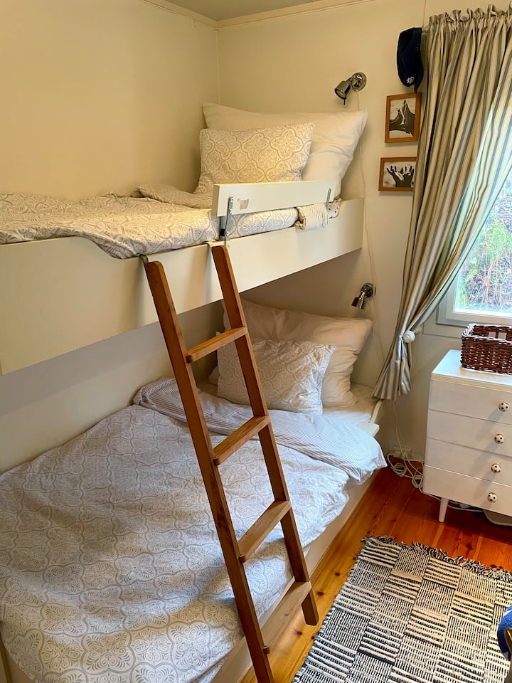 Unang silid - tulugan na may mga bunk bed at lababo. Portable fan.