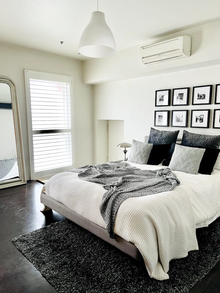 Dormitorio principal lleno de luz con aire acondicionado y baño privado