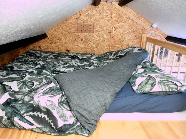 سرير مزدوج يمكن الوصول إليه عن طريق سلم.