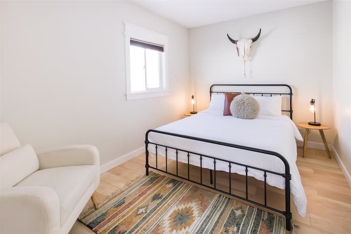 La chambre queen size dispose d'une literie toute neuve, d'un placard surdimensionné, d'un miroir au sol et d'un fauteuil. 
