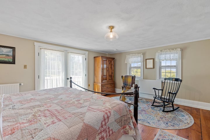 The master bedroom has a king bed, en suite bathroom with clawfoot tub, windows with mountain views, and french doors leading out to a second floor deck