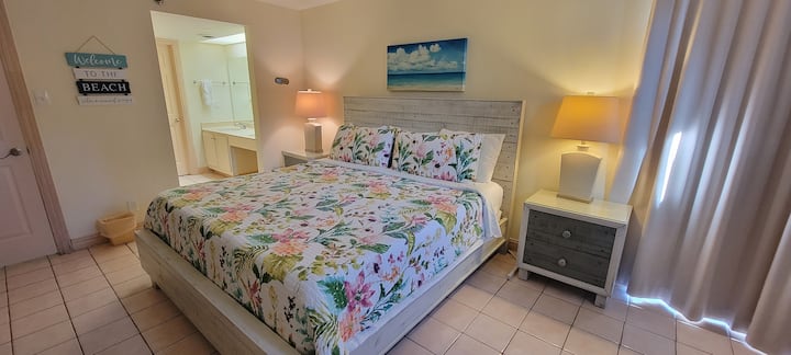 Rest easy in this bright, coastal bedroom featuring soft hues, natural light, and crisp linens. A peaceful retreat designed for comfort, it’s the perfect spot to unwind after exploring beaches, dining, and the relaxed charm of your getaway.