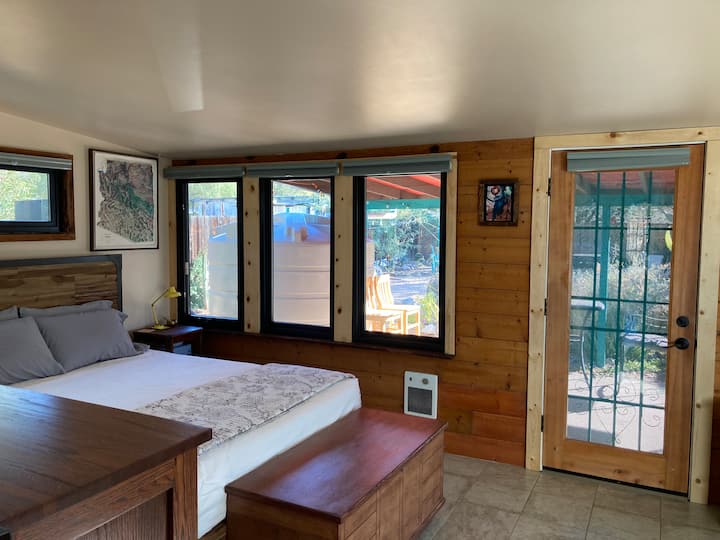 Chumba kikubwa cha kulala chenye mwangaza mzuri kinaangalia nje kwenye ua wa nyuma uliofungwa wa asili. 