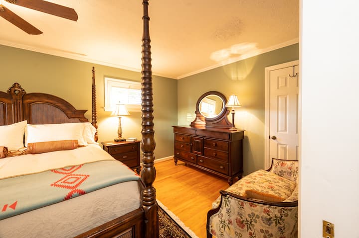 The master bedroom is an excursion into the realm of decadent luxury with a king bed, oriental rug, love seat all on pretty hardwood floors.