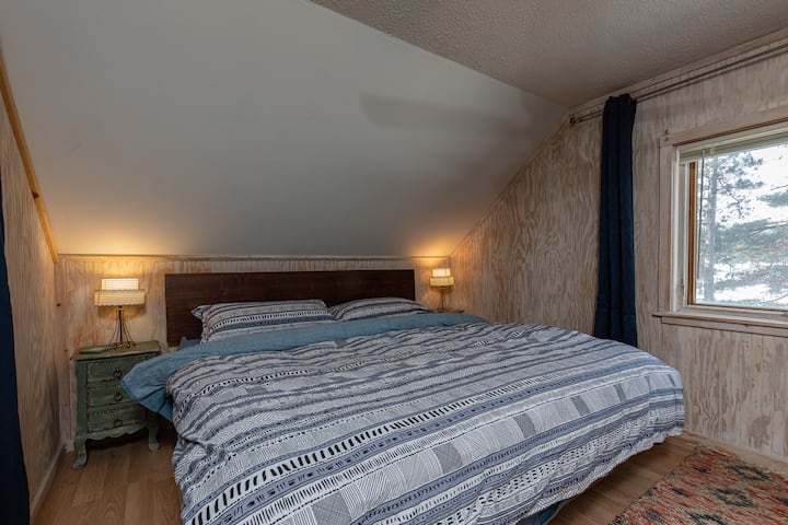 Bedroom 3 - King - Upstairs. Morning lake view - cozy down duvet and linens provided. Private seating area, closet & dresser in room.