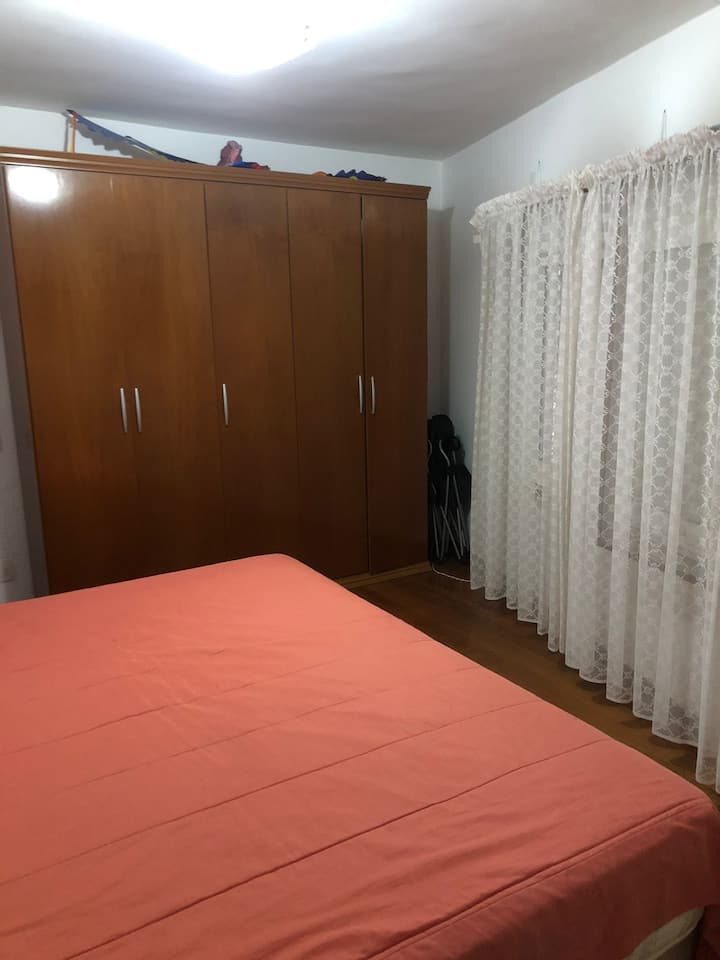 Dormitorio 2: cama tamaño king, ventana grande y un colchón adicional disponible, ubicado en la planta baja.