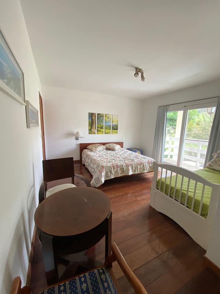 Dormitorio 3: dormitorio grande con balcón, cama queen, cama individual y colchón adicional debajo de la cama individual ubicada en el segundo piso.