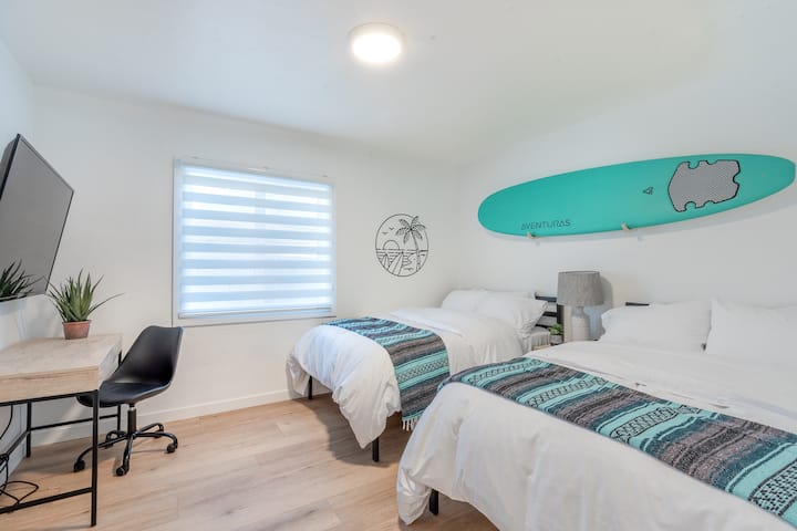 The surf room! Let us pray for surf! This room includes two double beds, night stand, desk or workspace with 55" TV that can be used as a monitor, dresser, closet, and plenty of room for the kids or large groups.