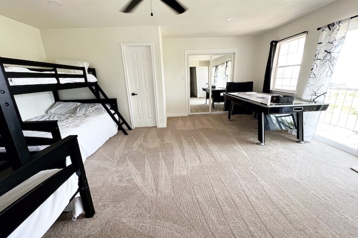 Во оваа спална соба на горниот кат може да се сместат до 6 лица.
За ваше уживање, обезбедени се маса за пинг-понг/воздушен хокеј, како и телевизор.
Лизгачката стаклена врата води до поплочен двор со простор за седење за да уживате во погледот на езерото.
