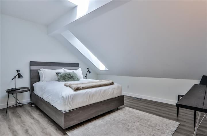 Master bedroom with a Queen Bed and a TV.
Motorized blinds for the skylight. 

Bedrooms are on the North side of the condo, away from the train tracks at the back.