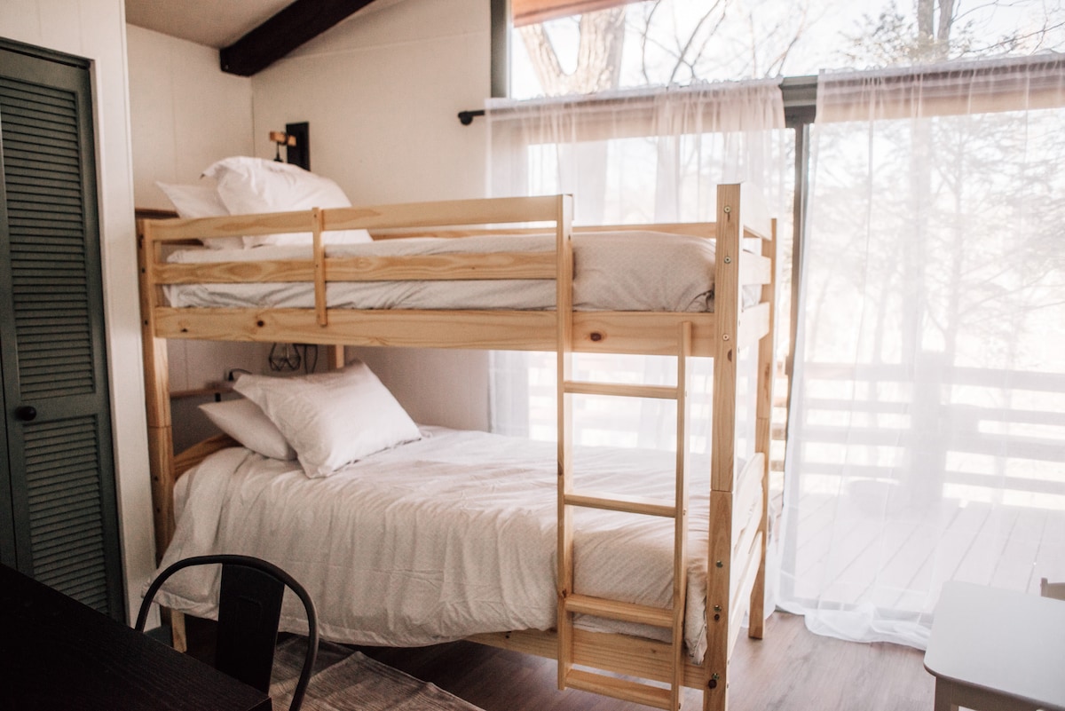 Main level.  Bunk bed room featuring vaulted ceilings with exposed beams.  Smart TV and child-sized table and chairs.