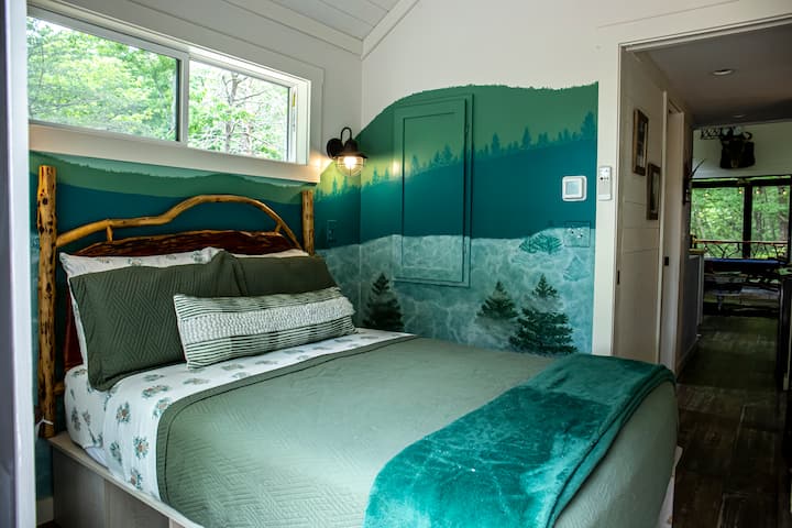 主卧配有一张标准双人床，位于主楼层，配有可上锁的门、床单、梳妆台和衣柜，衣柜内有衣架可供存放衣物。