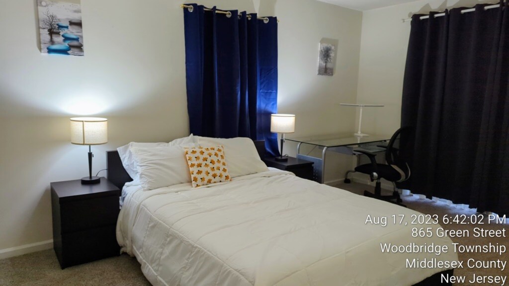 ห้องนอนที่สะดวกสบายพร้อมเตียงควีนไซส์ ห้องน้ำในตัว ม่านบังแสง และพื้นที่ทำงานเฉพาะ — เหมาะสำหรับผู้เข้าพักระยะยาวในอพาร์ทเมนท์ 3 ห้องนอนที่กว้างขวางและตกแต่งครบครันในวูดบริดจ์ นิวเจอร์ซีย์