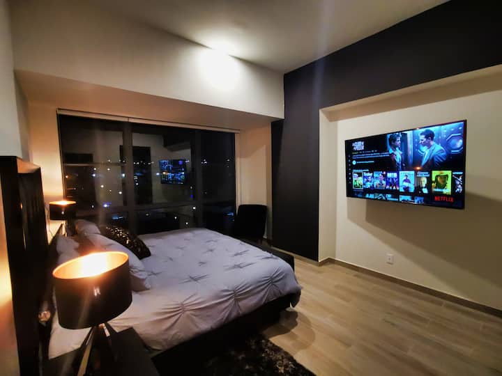 Habitación principal con cama King Size, vista panorámica y Smart TV de 60" UHD.