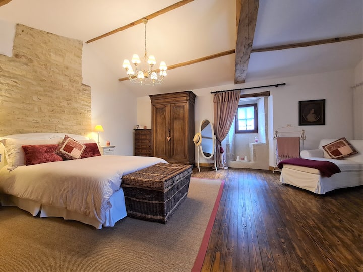 Bedroom 1 - wooden floor, beams and exposed stonework.