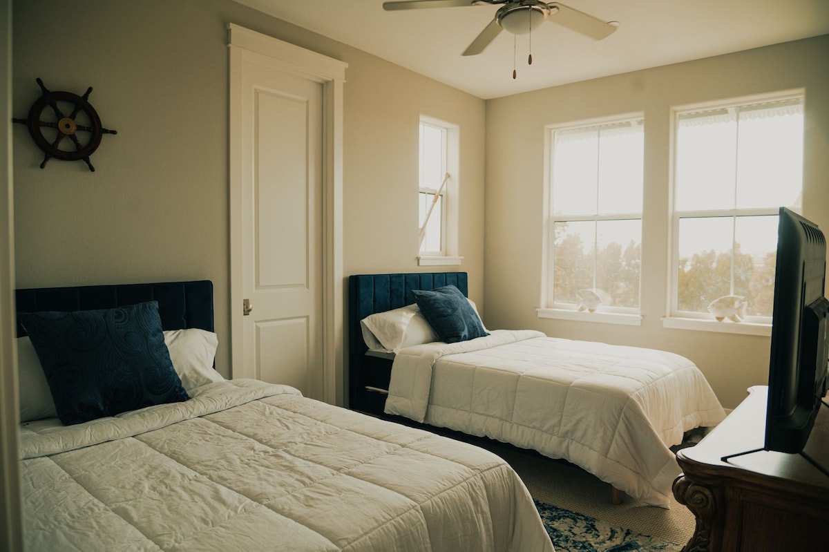 ห้องนอน #3 มีเตียงควีนไซส์ 2 เตียงทีวีตู้เสื้อผ้าขนาดใหญ่และตู้เสื้อผ้า