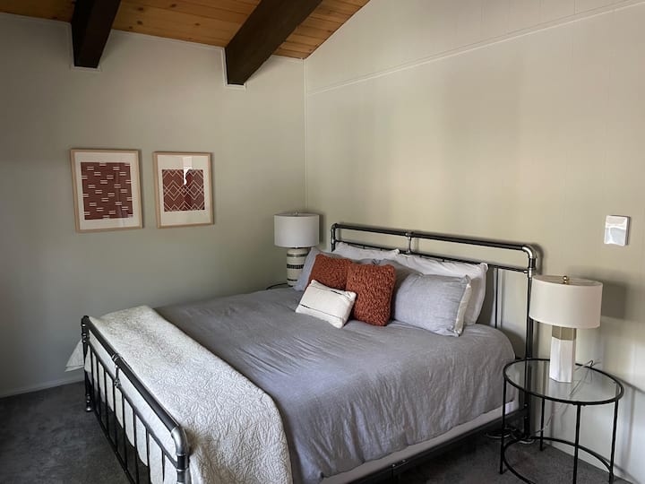 dormitorio principal privado en la planta superior con techos abovedados y una cama tamaño king.
