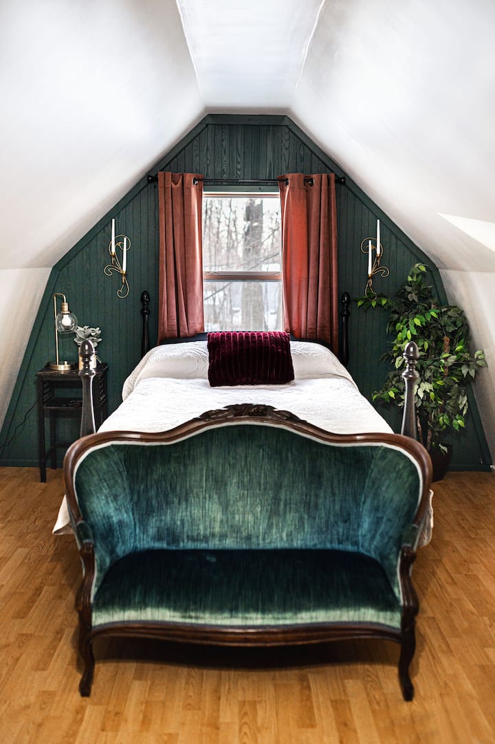 The main bedroom sleeps two in this double bed with a view of the backyard and woods