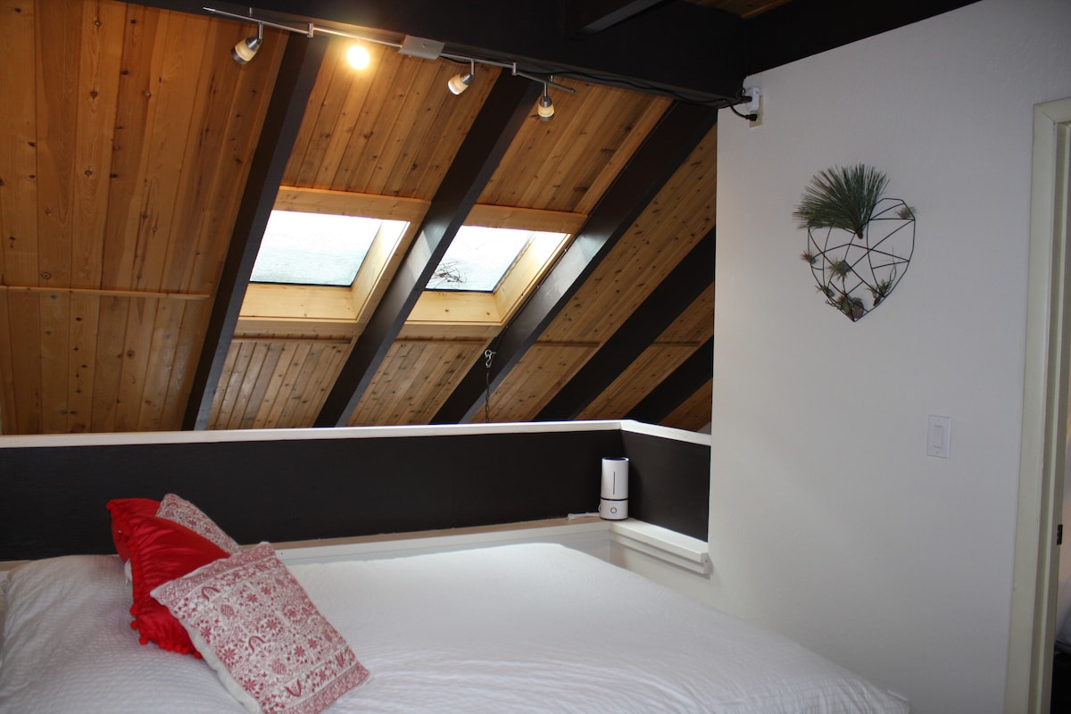 The second floor loft features a comfy queen bed and has a private full bathroom. There is a 1/2 wall that opens to the downstairs living room, because of this small children should stay downstairs.