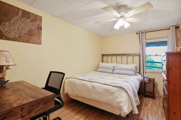 Chambre de niveau inférieur avec lit queen size, demi-baignoire privée et bureau. 