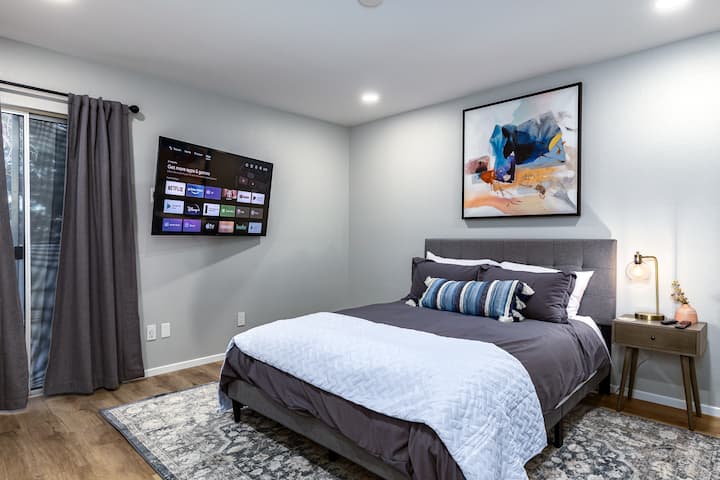 Slaapkamer 2 met queensize zilver 11,75" medium stevig matras en Casper Essential Kussens. 55" Sony televisie met meer dan150 kanalen en alle lokale zenders. Toegang tot alle streamingapps. Schuifregelaar met toegang tot balkon boven.