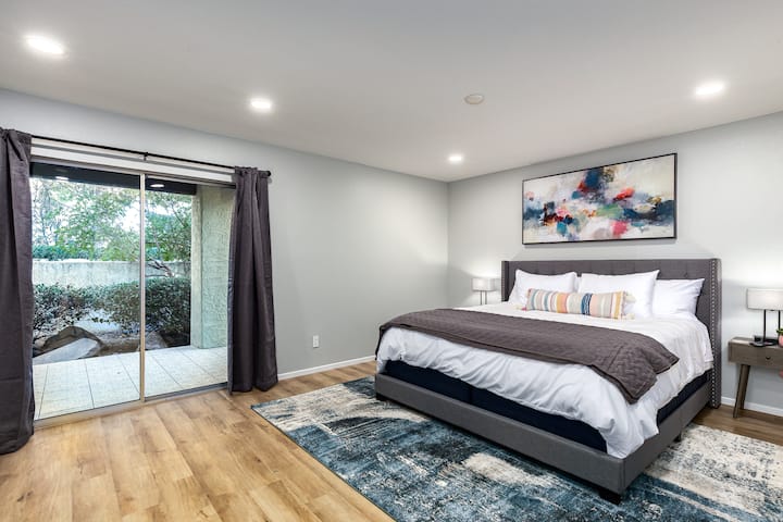 Hoofdslaapkamer met kingsize bed en iSeries Hybrid 3000 Medium Matras en Casper Essentiële kussens. 65inch Sony-televisie met meerdan150 kanalen en alle lokale zenders. Toegang tot alle streamingapps. Schuifregelaar met buitentoegang tot overdekte patio.