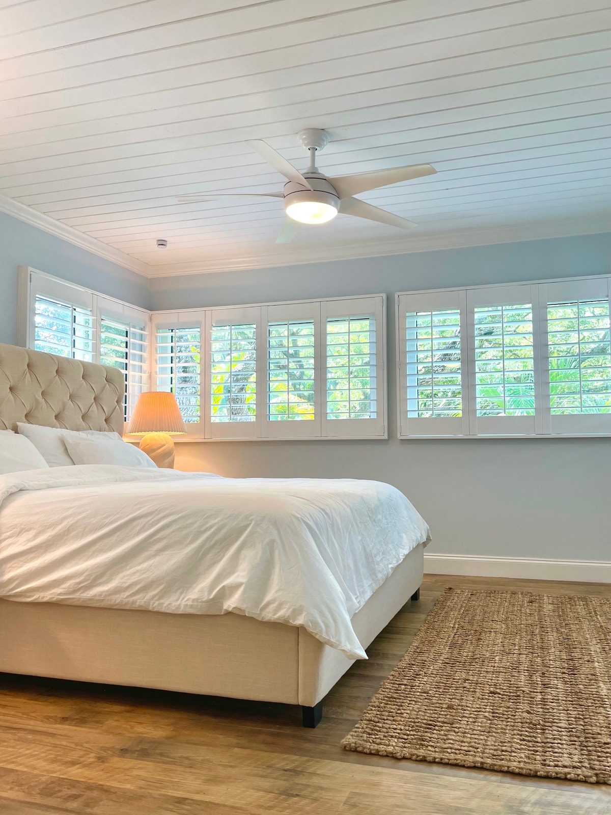 Tropics Bedroom (No. 3) with king bed on second open loft level. Opens to a private bathroom (with clawfoot tub/shower), sitting area with smart TV (YouTube TV provided) and workspace, closets, laundry and roof deck.