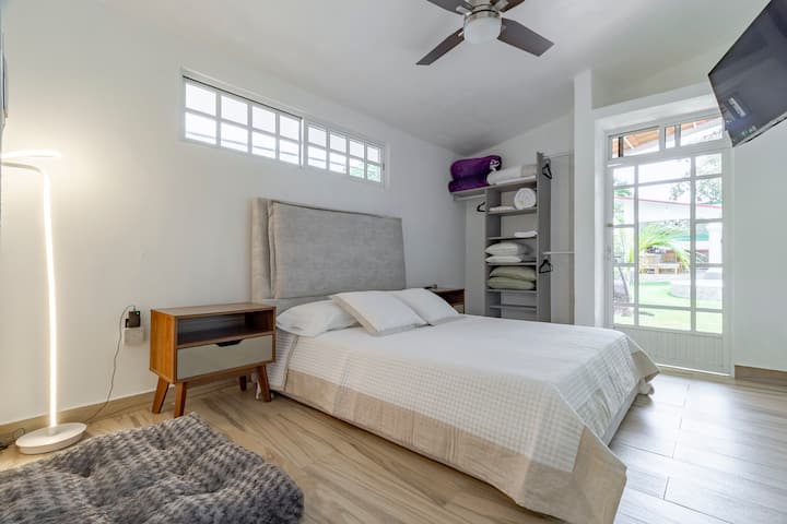 Main room. Delicious headboard to recharge. 4K Smart TV. Remote control fan. Floor lamp. Direct access to the garden. Comfortable on both sides. Accessories to connect chargers and other things. Closet with hooks. 