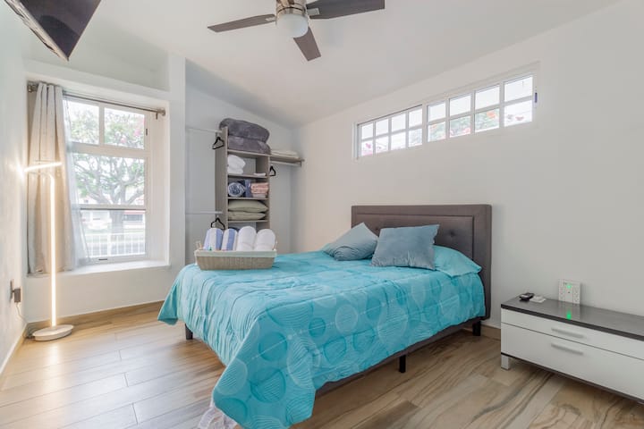Quarto Azul. Spacious room with comforts from both sides. Queen-size bed with comfortable headboard. Multi-contact with USB inputs for cell phone charging. Floor lamp. Remote controlled fan. 4k TV mounted on the wall. Closet with hooks.