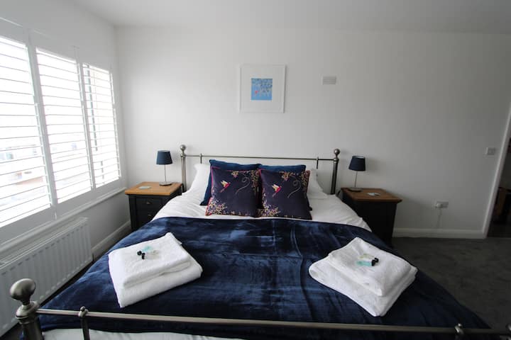 Main bedroom:  A comfy super king size bed with luxurious cotton bedding.  There is a double wardrobe with hangers, chest of drawers, mirror and hairdryer for your use.