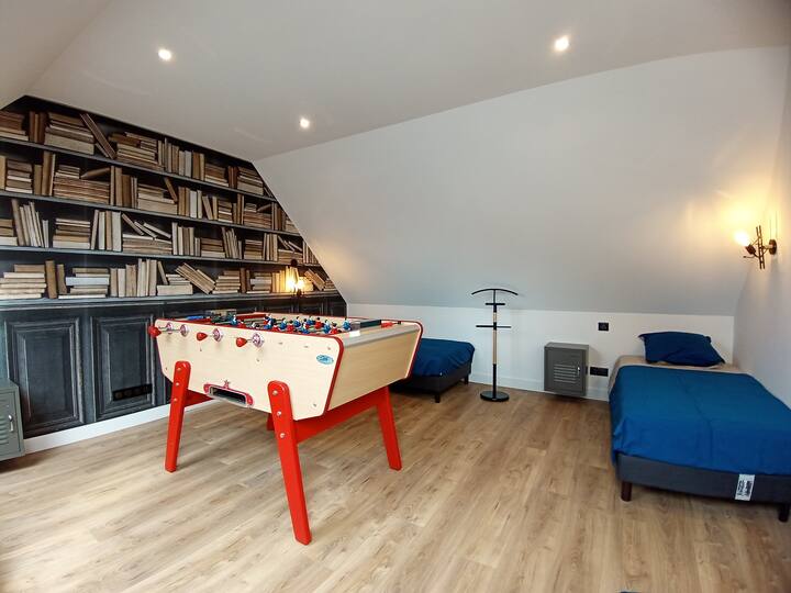 Upstairs bedroom with four single beds and a foosball table.