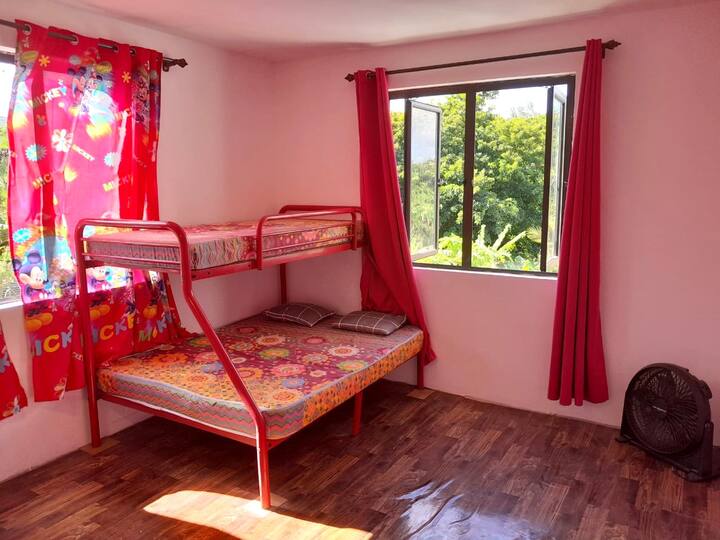 Ružičasta soba s krevetom na kat. Dostupni su dodatni madraci. 