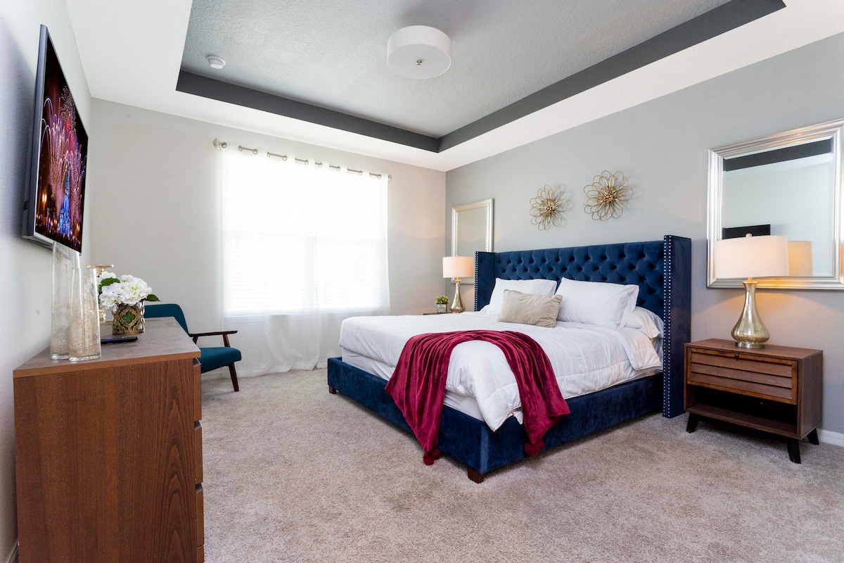 Dormitorio principal en el primer piso (planta baja) con decoración moderna, cama tamaño king, baño doble en suite con ducha a ras del suelo. El dormitorio tiene TV montada en la pared y vestidor.