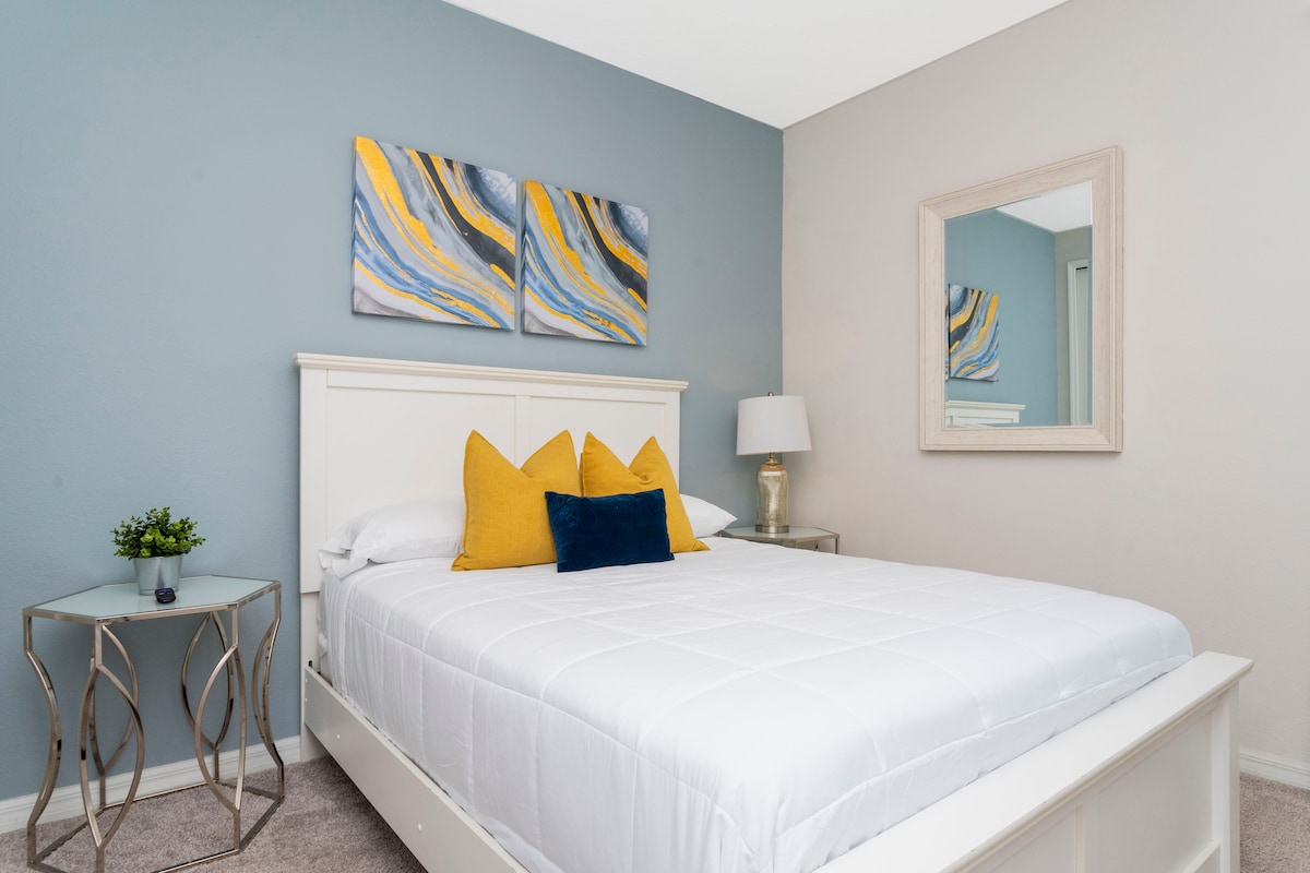 Suite 2 (segundo piso) - Cama tamaño queen con baño doble adjunto "jack-and-jill" con combinación de bañera y ducha. El dormitorio tiene un televisor LED montado en la pared.