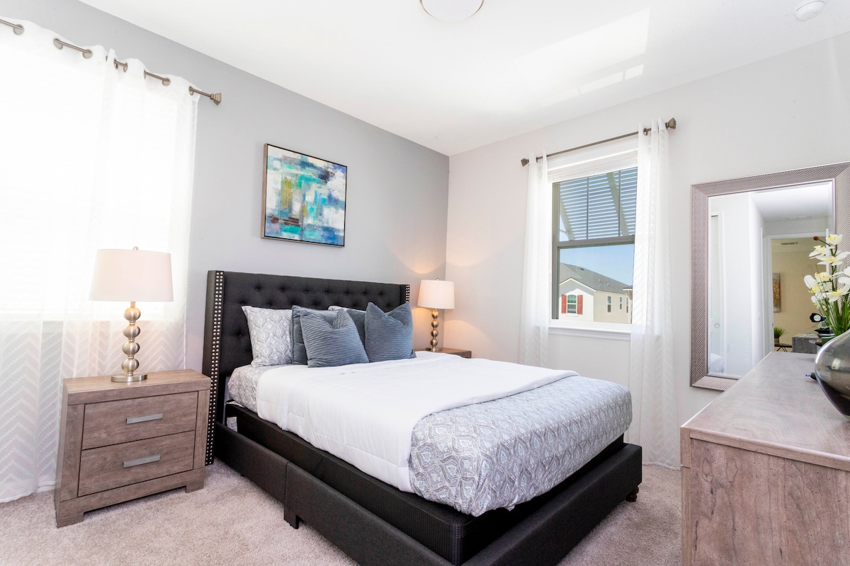 Dormitorio 6 (segundo piso): cama tamaño queen con baño privado y ducha a ras de suelo. El dormitorio tiene un televisor LED montado en la pared.