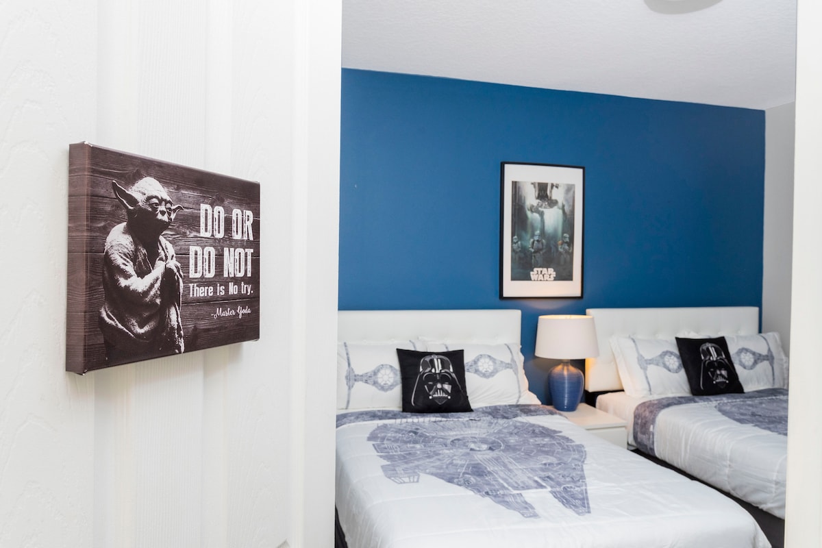 Dormitorio 5 (segundo piso): dos camas completas con baño compartido con combinación de bañera/ducha. El dormitorio tiene un televisor LED montado en la pared.