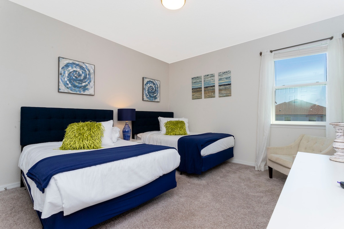 Dormitorio 8 (segundo piso): dos camas completas con baño compartido de doble furgoneta "jack-and-jill" con ducha a ras del suelo. El dormitorio tiene un televisor LED montado en la pared.