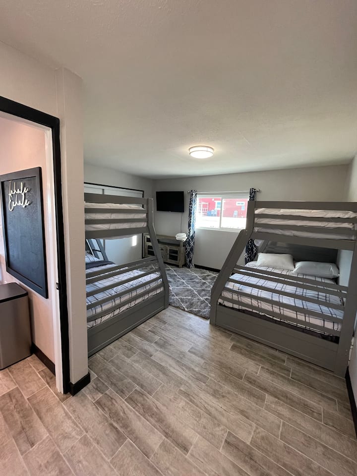 Habitación infantil de la casa, 2 literas individuales en la cama queen superior en la parte inferior, sistema de juegos atari, televisión con aplicaciones inteligentes y un baño completo privado.