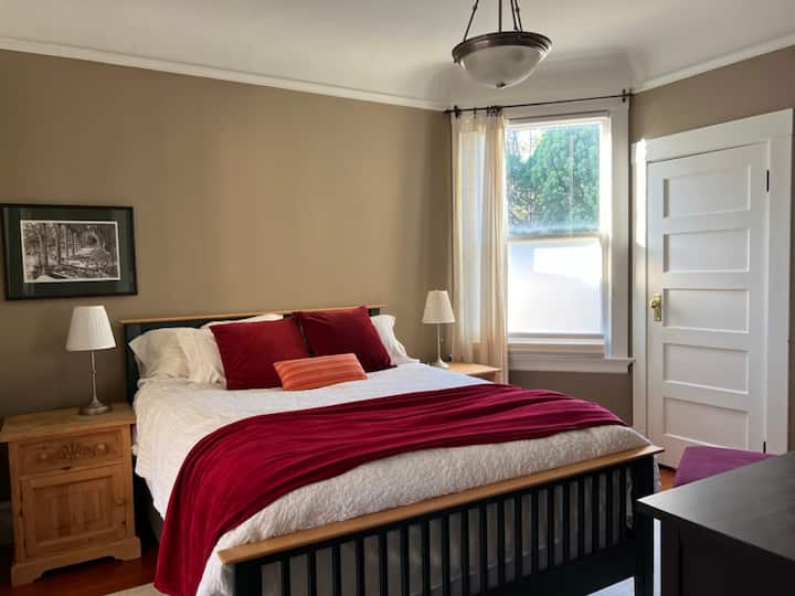 Главна спална соба со брачен кревет, плакар, стол за читање, гардеробер, штандови за две ноќевања и сенка за затемнување на собата.