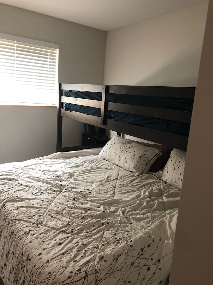 Segundo dormitorio con litera individual sobre una cama tamaño king con cama nido