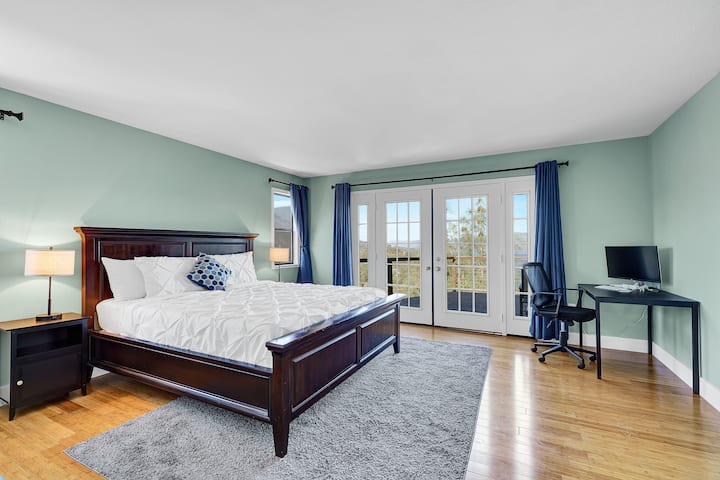 Primary (master) bedroom with King Bed, dedicated computer desk/chair, private bath, walk-in closet, access to wrap around deck and a splendid view of the Clear Lake and MT. Konocti.