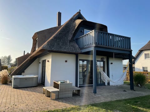 Luxurious thatched house with fireplace and sauna