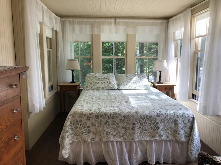 Познатата соба „аквариум“ на горниот кат, исполнета со прекрасна светлина и поглед кон езеро

Во собата има и сопствена бања лево од оваа фотографија.