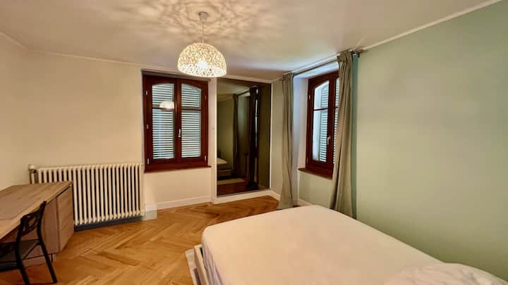 Dormitorio verde con cama doble.