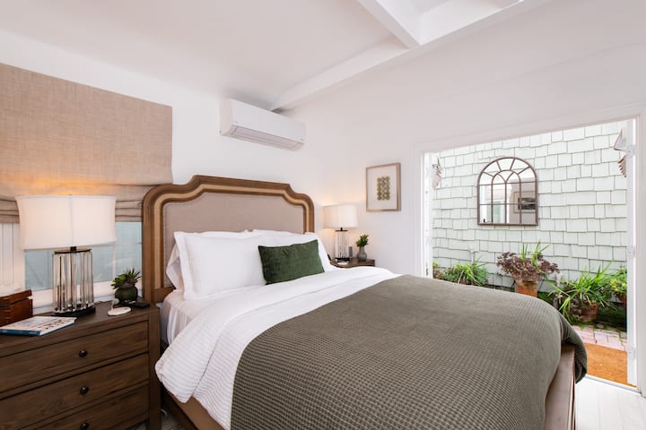 חדר שינה ראשי למטה עם דלתות צרפתיות שמובילות לפטיו בחצר האחורית. 