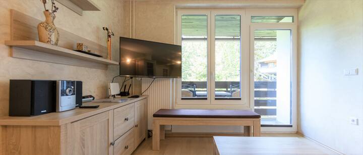 Дневна соба со телевизор и поглед кон природата