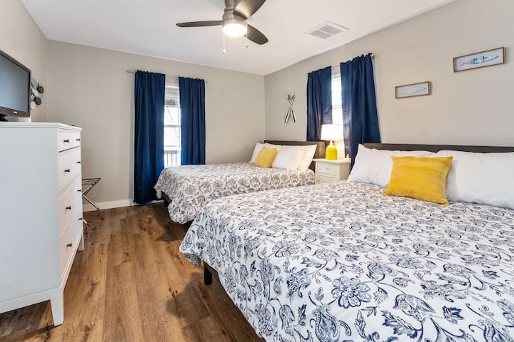 בחדר השינה השני יש מיטת קווין סייז וטלוויזיה עם Roku. נוף לאגם מחוץ לחלון.