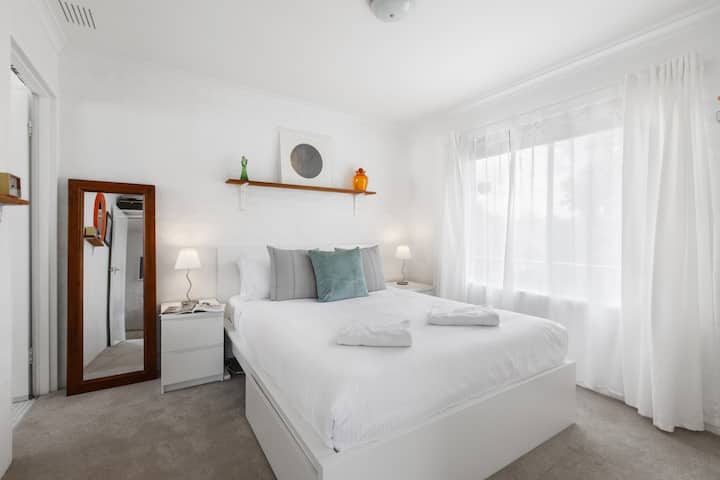 The bedroom is beautifully styled with a queen-sized bed, topped in crisp white linens for a good night’s sleep.